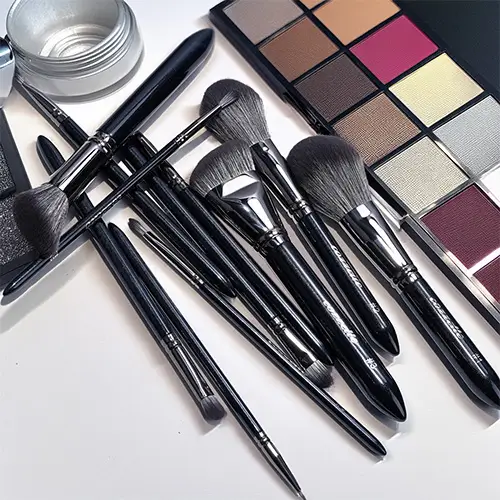 Cozzette Beauty professional makeup brushes with eyeshadow palette showing a range of brush sizes for blending, precision, and full-face application